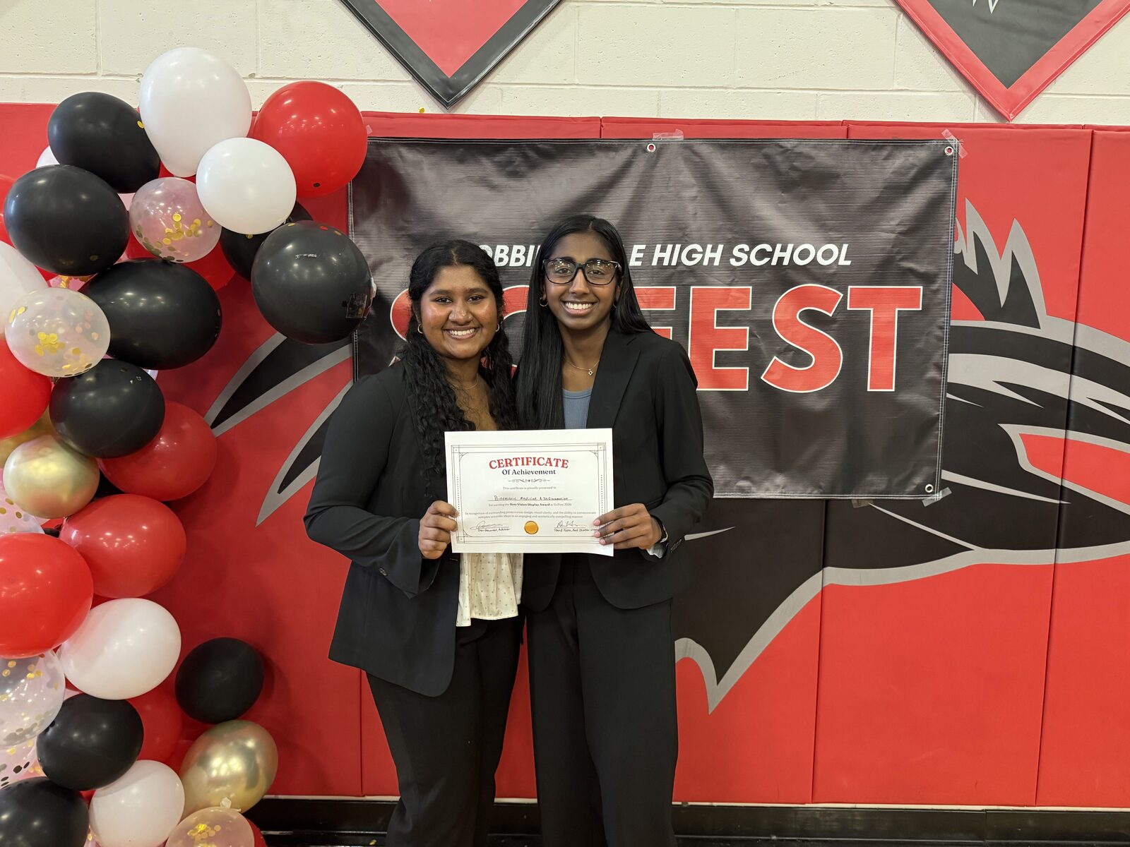Arthi Meiyyammai Subramanian holds her 1st Place Division 1 trophy and certificate in front of the SciFest banner.