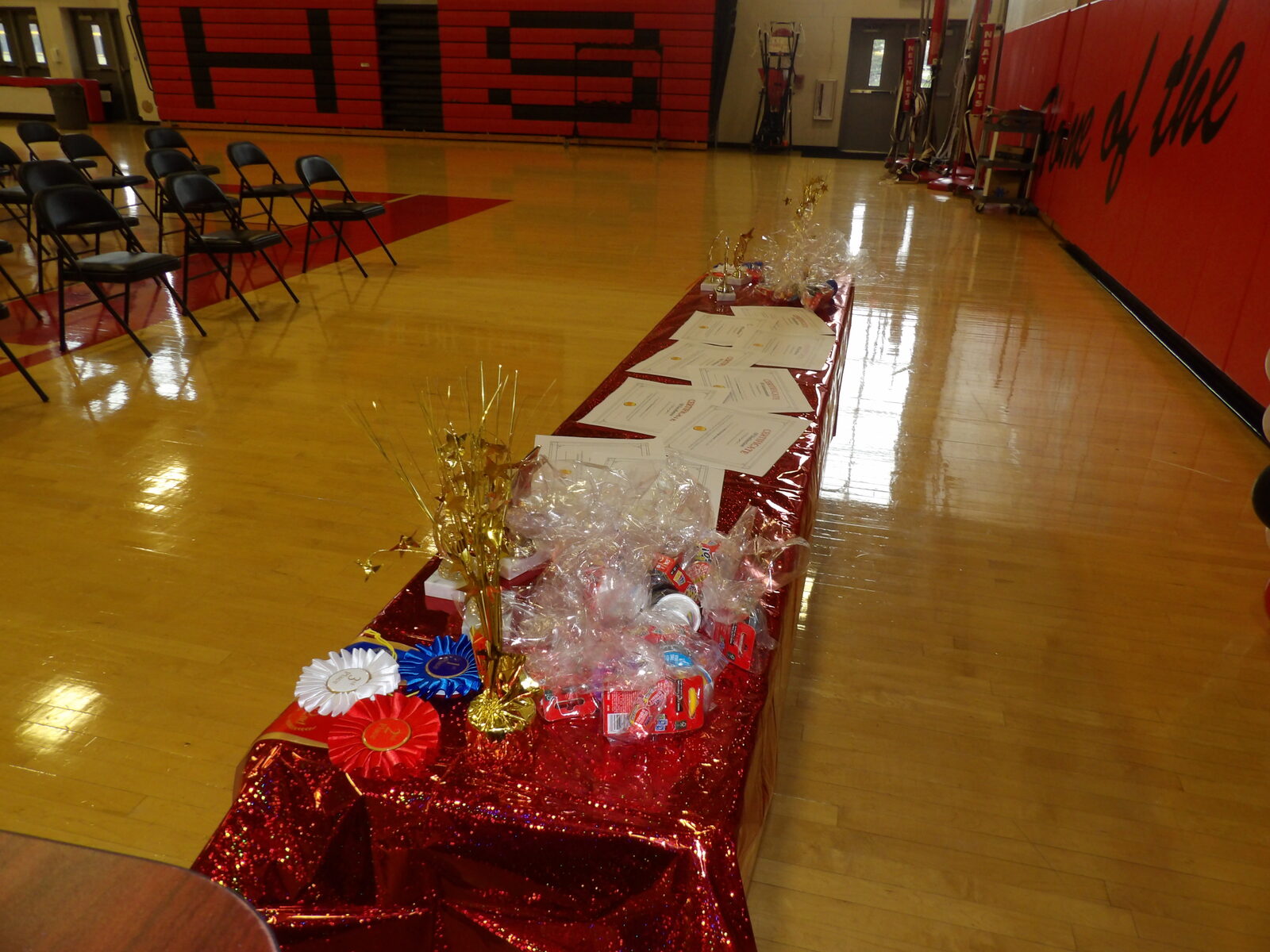 The SciFest 2026 awards display table, set with ribbons, trophies, certificates, and prize baskets in the Robbinsville High School gymnasium.