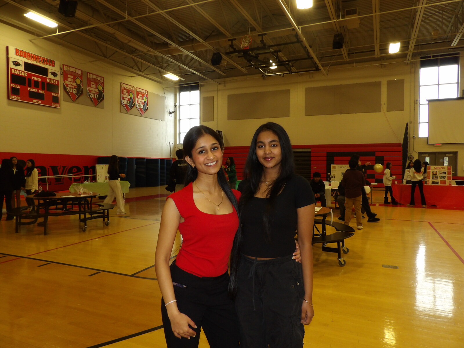 Two students in the gym near the HOSA and SIREN booths.