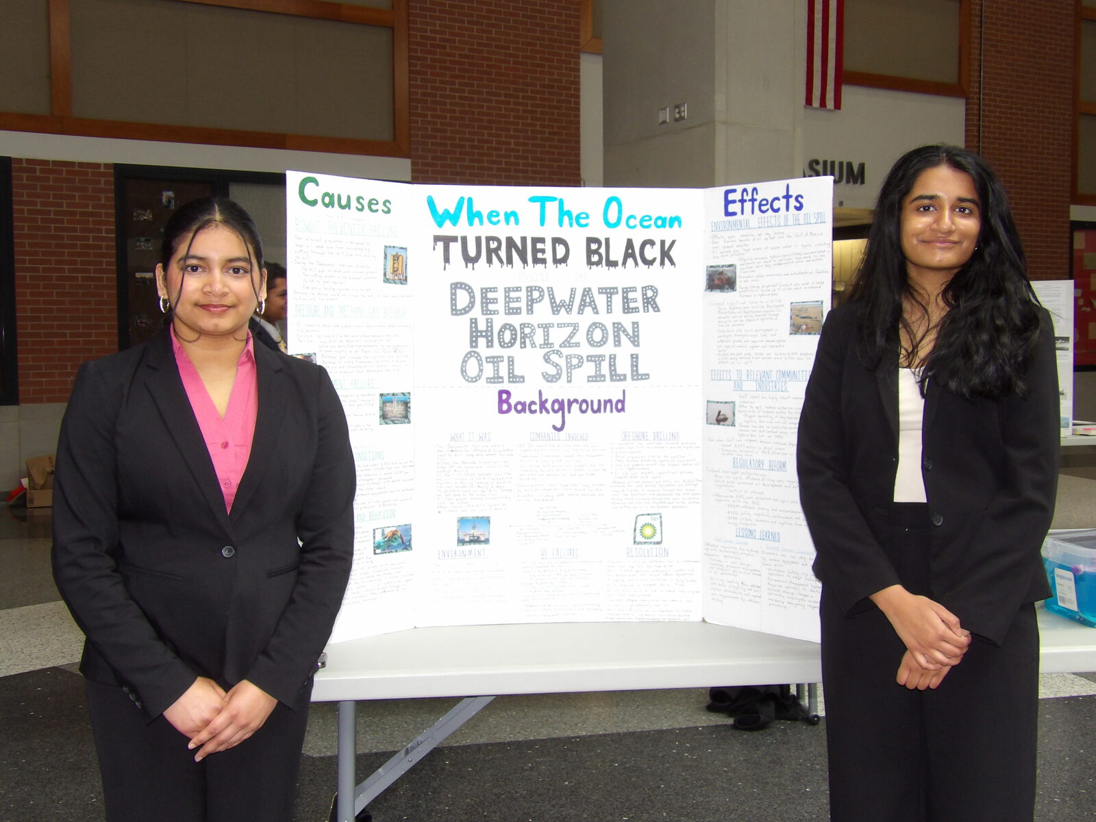 Two SciFest 2026 presenters stand beside their award winning board on the Deepwater Horizon oil spill.