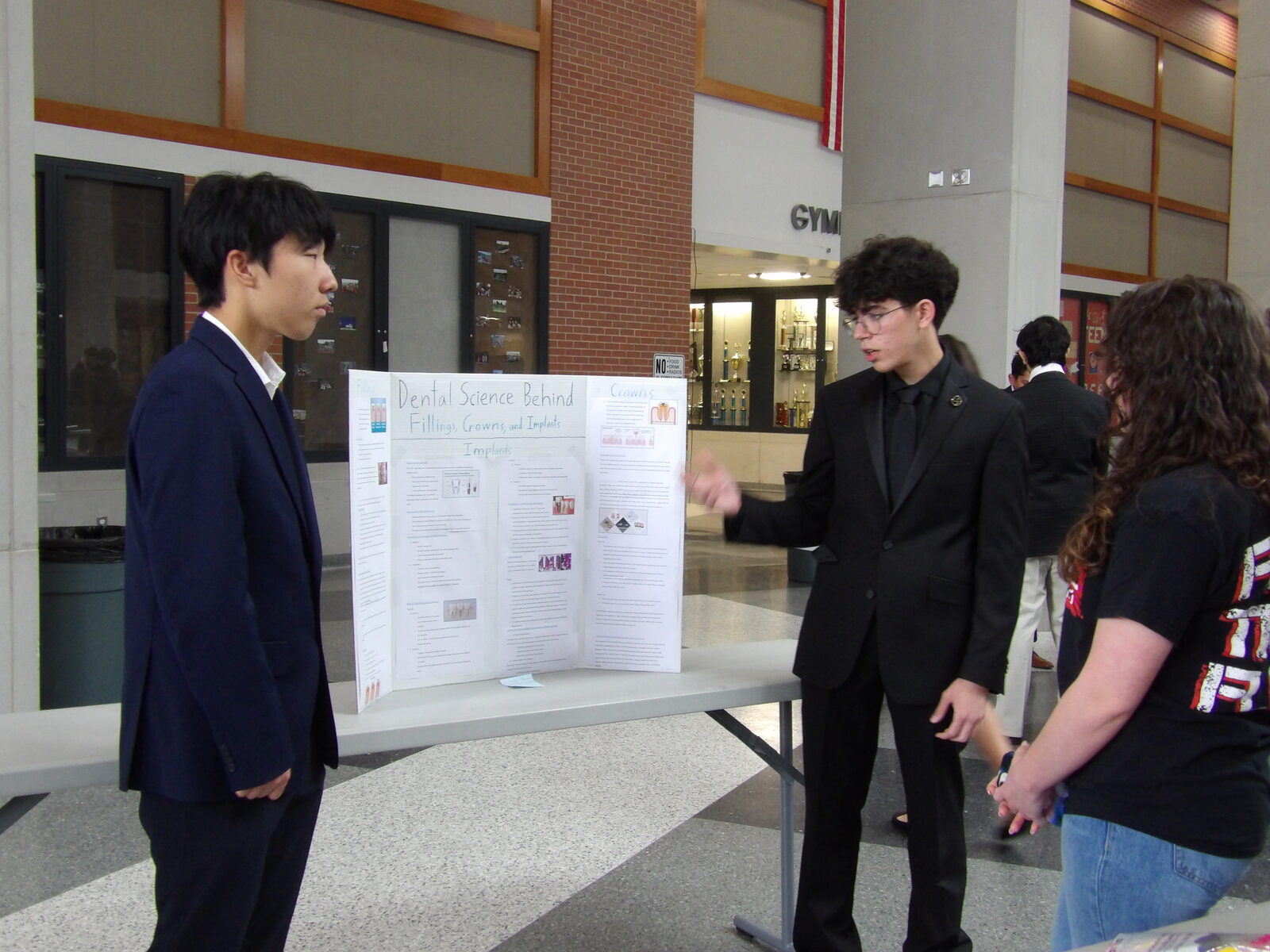A judge reviews a presenter's research board.