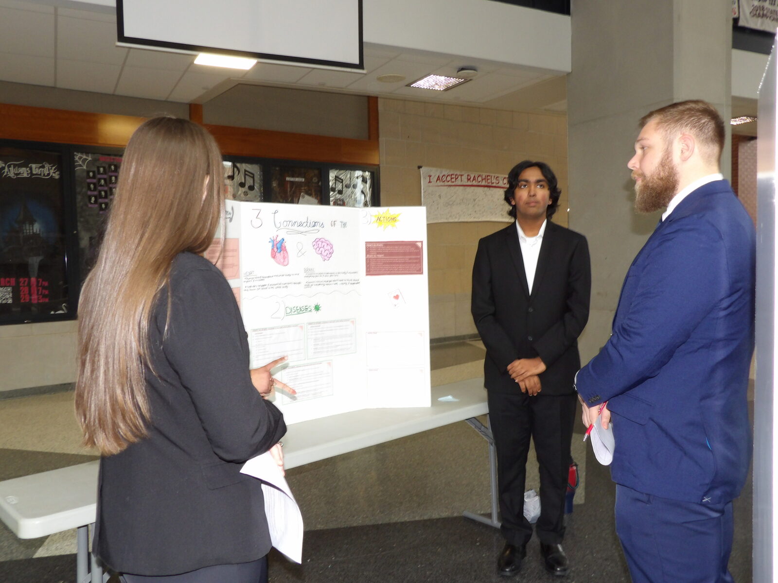 A judge questions two presenters during a round of judging.