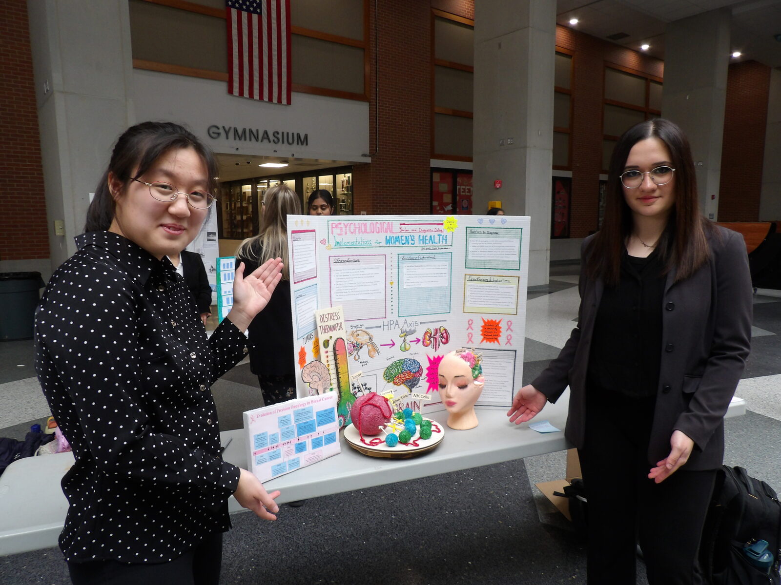 A SciFest 2026 presenter stands beside her research board.