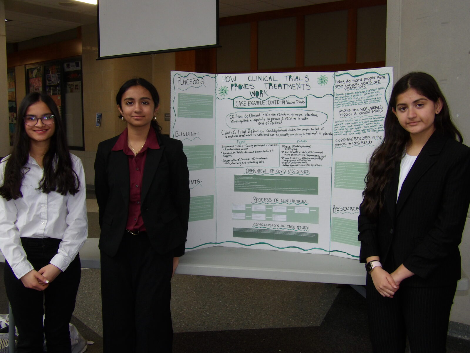 A group of SciFest 2026 presenters beside their board.